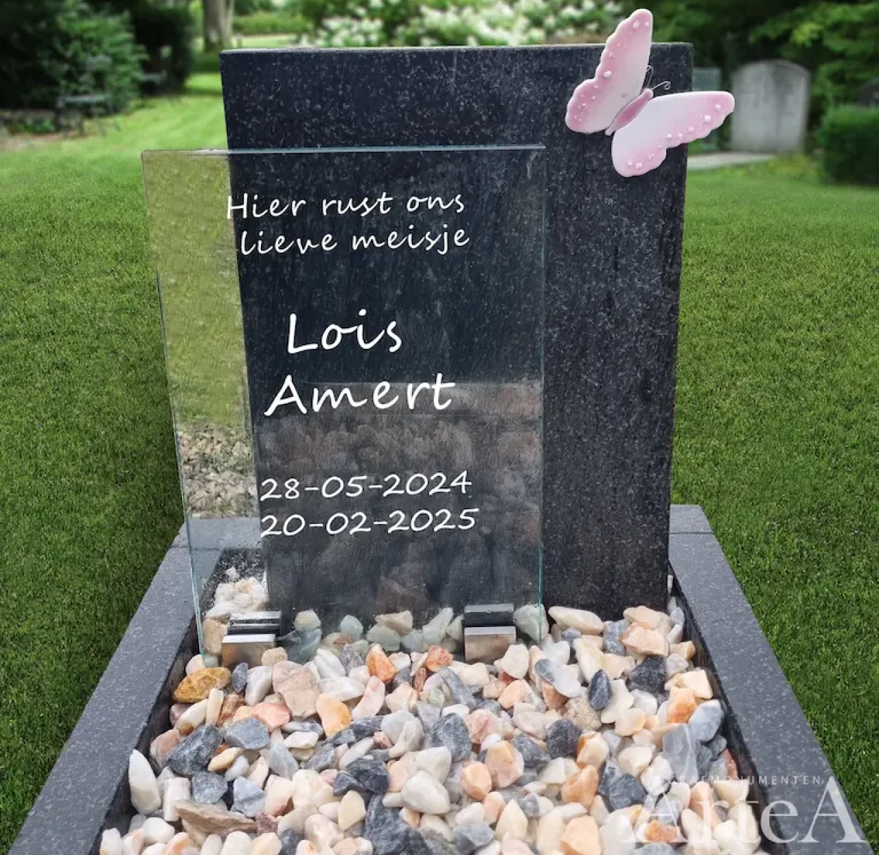 Kindergrafsteen met glasplaat en roze vlinder