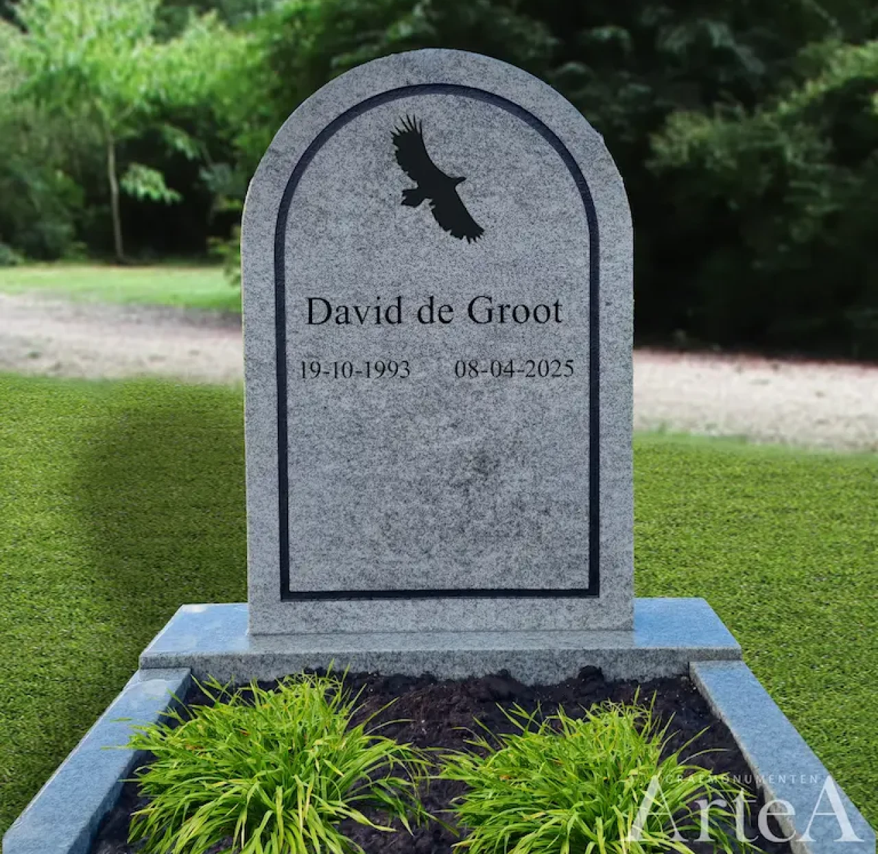 grafsteen met wit natuursteen en een afbeelding van een vogel