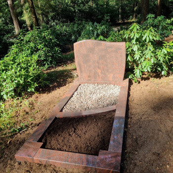 grafmonument in doorn rood met tuin en split grafsteen van graniet