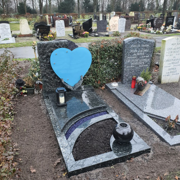 grafmonument met blauwe glasplaat en foto. Deze grafsteen is uniek, bijzonder en ook nog een prachtig