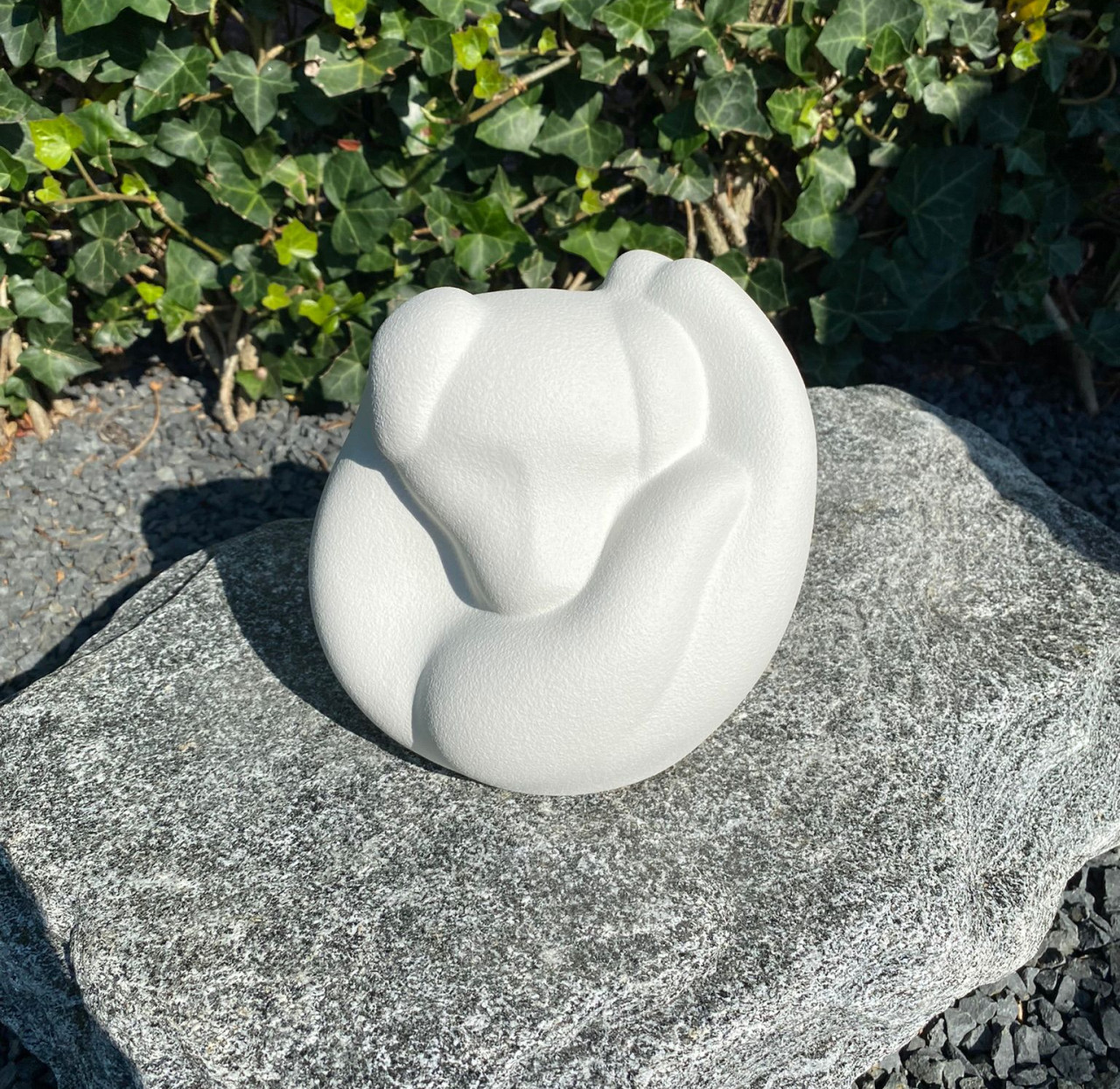 Honden urn van keramiek in een hand